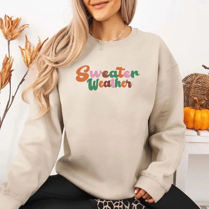 Sweater Weather Fall Vibes unisex crewneck sweatshirt featuring a cozy autumn-inspired graphic design for fall in Sand.